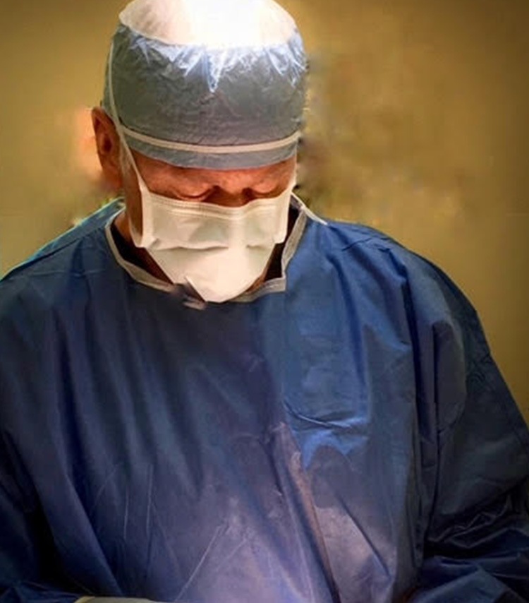 Dr. Carpenter operating while wearing a surgical masks and scrubs